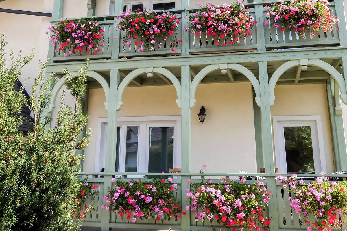 En byggnad med flera våningar, där varje våning har balkonger som är dekorerade med blomlådor.