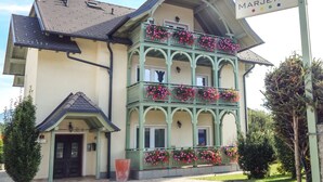 Un edificio con un letrero que dice "Vila Marjeta". Presenta una estructura de varios pisos con balcones decorados con flores.