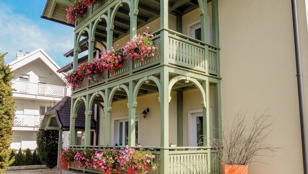 Un edificio de varios pisos con balcones decorados con flores.