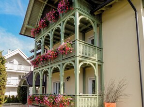 A multi-story building with balconies adorned with flowers. - Apartments Vila Marjetica (Bled)