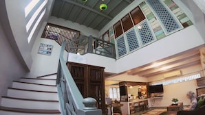 A multi-level interior with a staircase, a kitchen area, and a seating area. - The White Houses (Hua Hin)