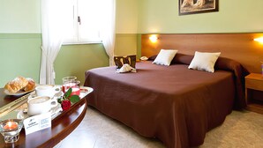 A hotel room with a bed, a bedside table with a lamp, a tray with breakfast items, and a painting on the wall. - Yellow Park Hotel (Arienzo)