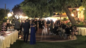 An outdoor event with a large tree, tables with food, and people gathered. - Yellow Park Hotel (Arienzo)