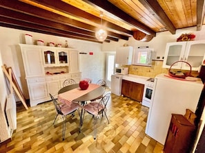 Una cocina compacta con una mesa de comedor, sillas y electrodomésticos básicos.