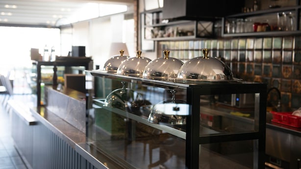 A bar area with a glass display case containing several wine glasses and a selection of bottles. - Hotel Simsek (Edirne)