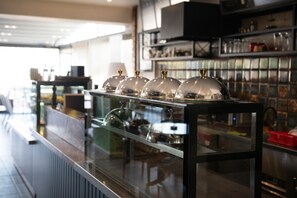 A bar area with a glass display case containing several wine glasses and a selection of bottles. - Hotel Simsek (Edirne)