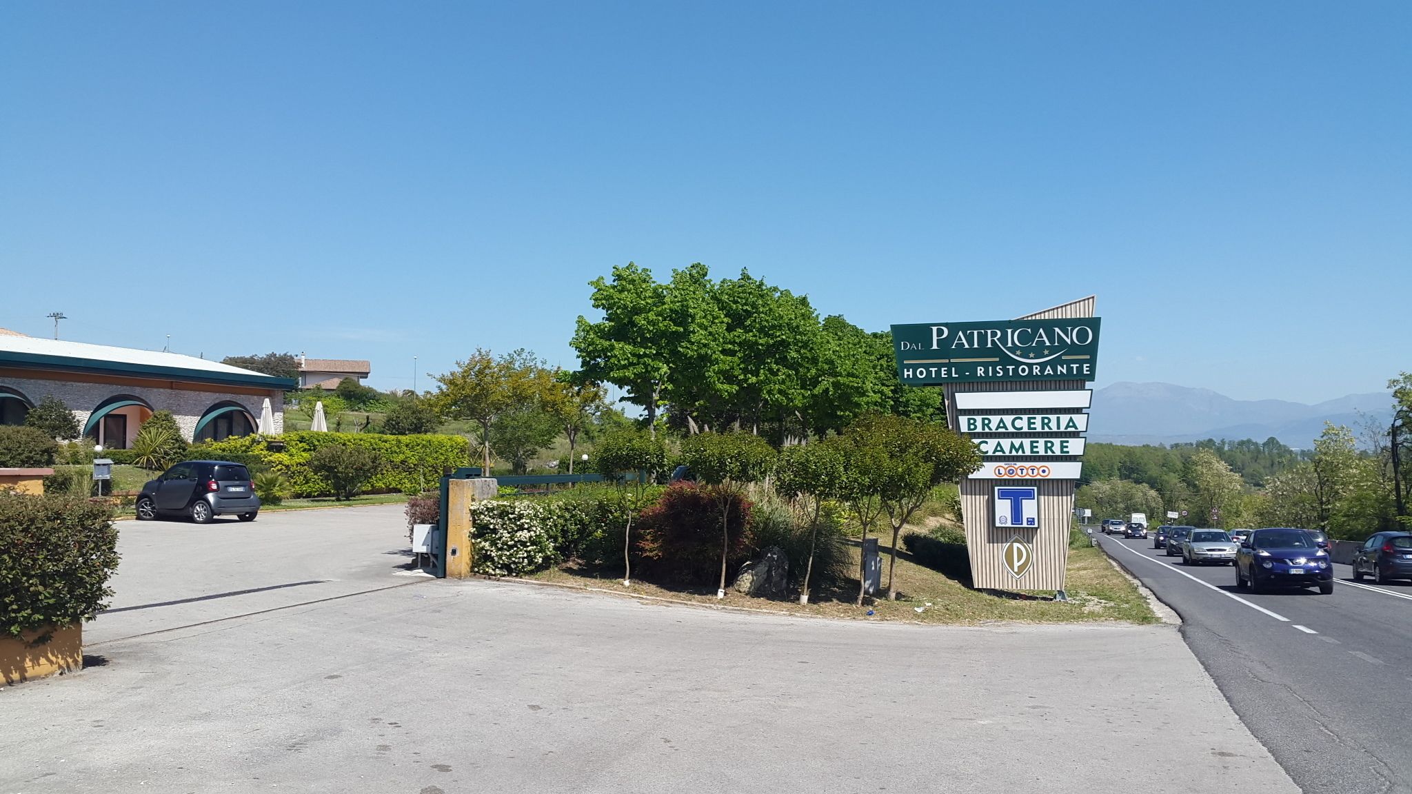 A hotel sign with "Patricano Hotel - Ristorante" and "Braceria Camere" indicating amenities.