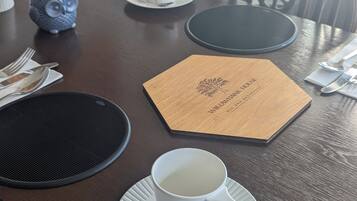 Una mesa de comedor dispuesta con una taza blanca, un plato, cubiertos y un menú.