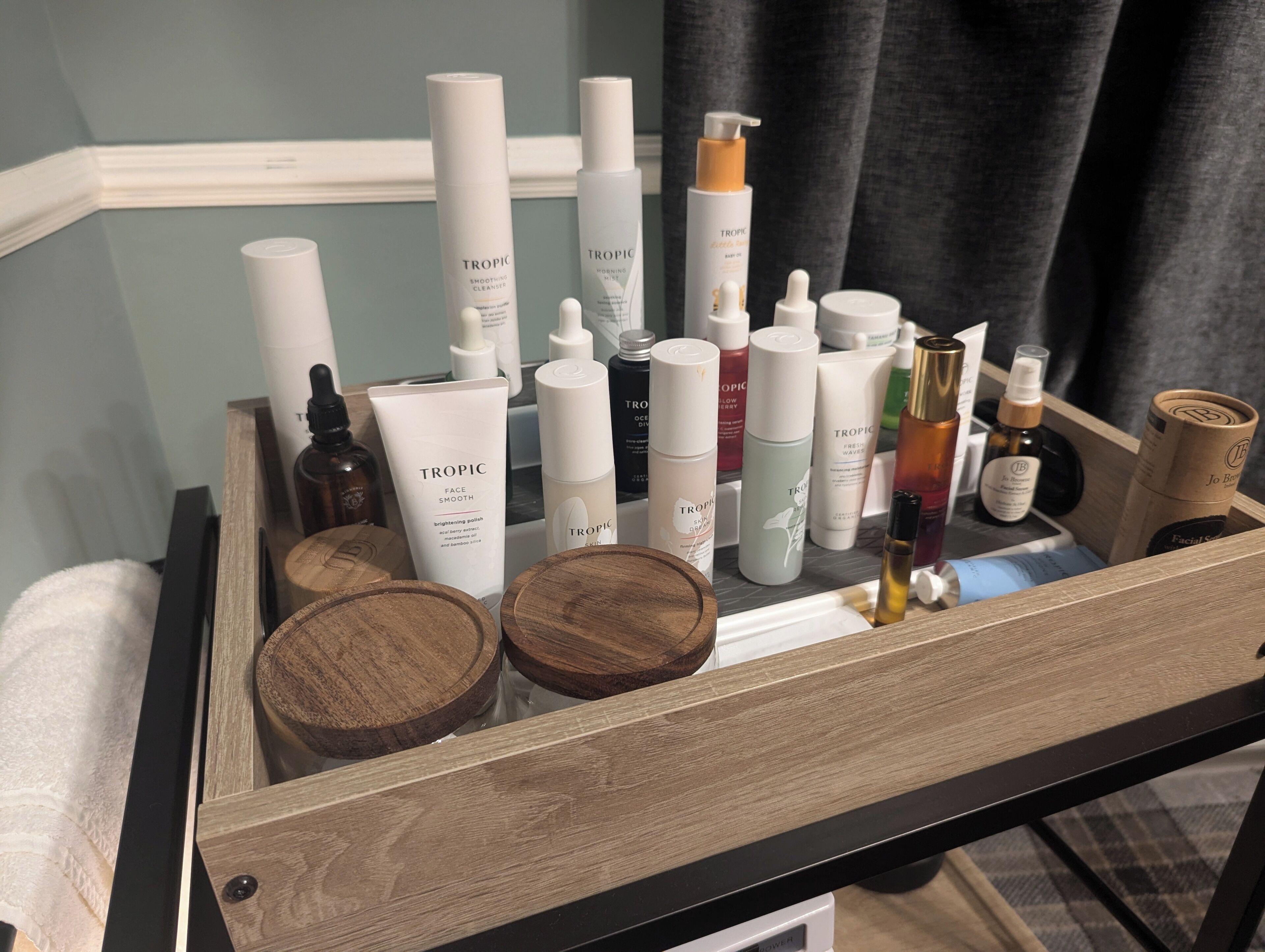 Un plateau en bois contenant divers produits et contenants de soins pour la peau.
