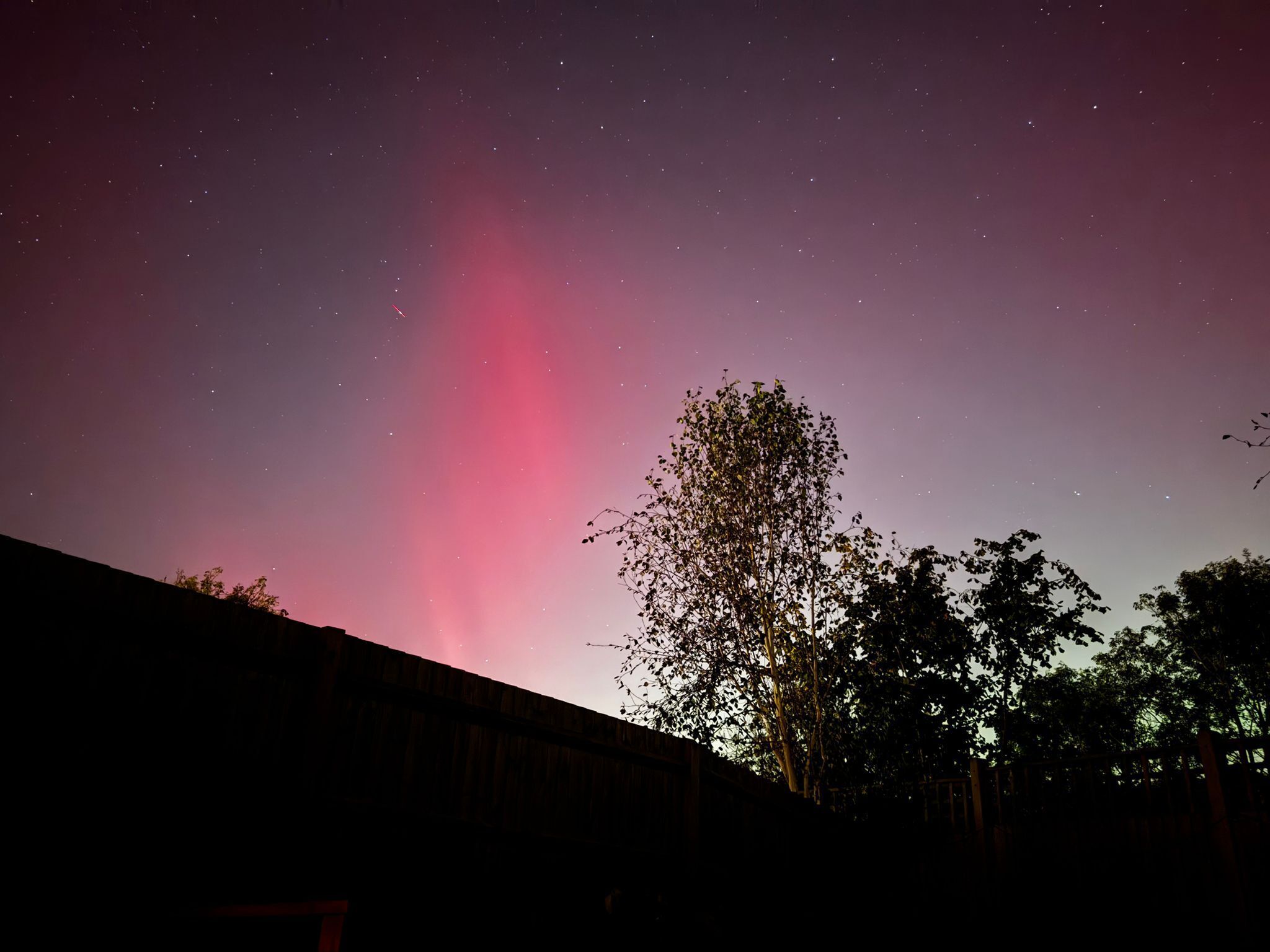 A night sky with stars and a visible aurora.