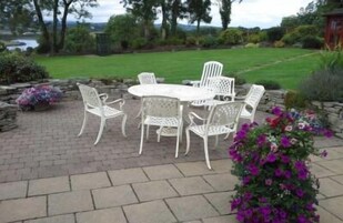 Un patio al aire libre con una mesa redonda y seis sillas.