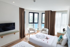 A hotel room with a bed, two chairs, a TV, and a window. - My Villa Hotel Airport (Ho Chi Minh City)