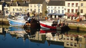 A harbor with boats docked, buildings with shops, and a restaurant.