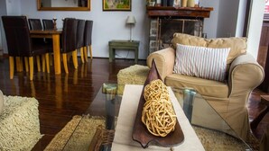 Un salon comprenant une table à manger, des chaises, un canapé et un objet décoratif posé sur une table.