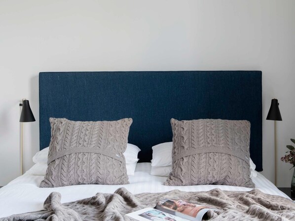 A neatly made bed with a dark headboard, two matching pillows, and a magazine on the bed. - Pembroke Hall (Dublin)