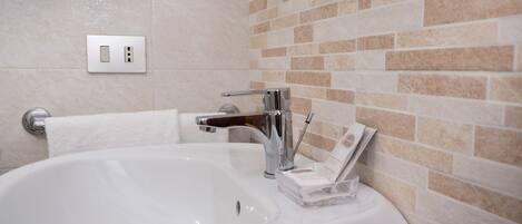 A bathroom with a white bathtub, a chrome faucet, and a towel rack.