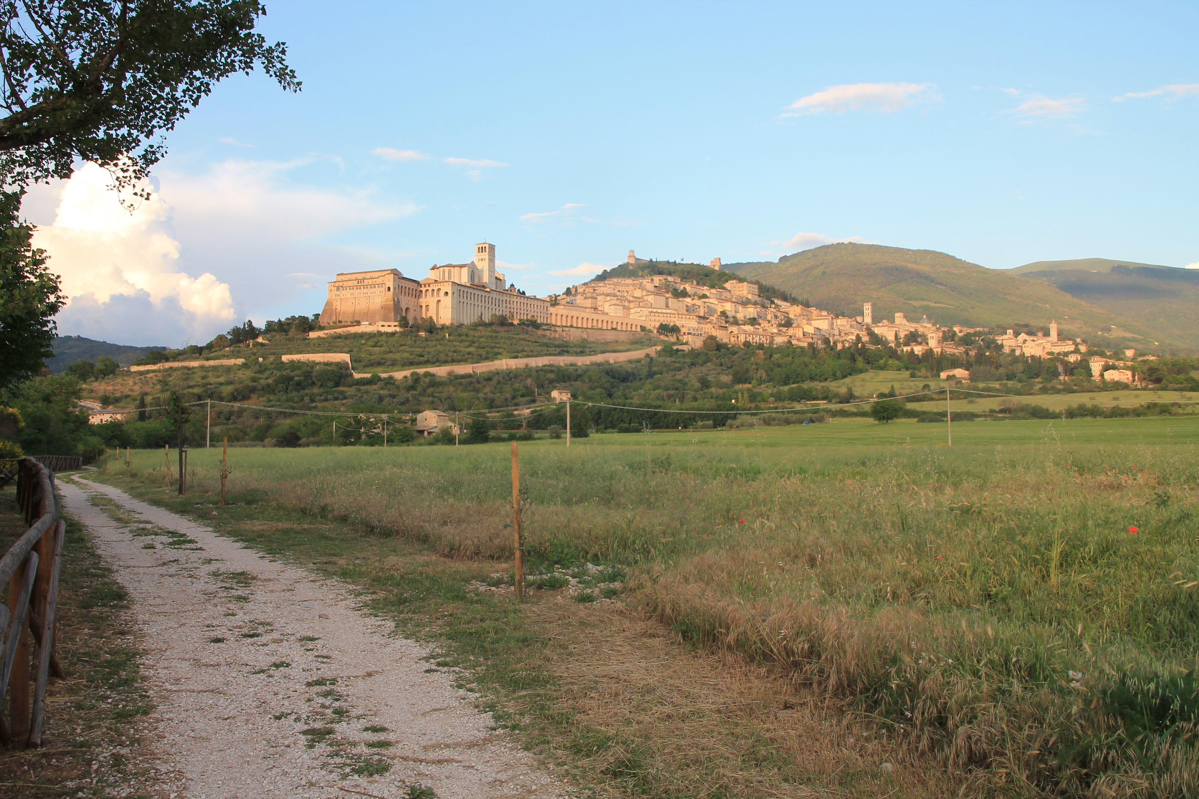 Un ensemble de bâtiments historiques situés sur une colline, auxquels on accède par un sentier de terre.