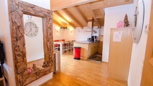 A wooden-framed mirror, a kitchen with a wooden floor, and a dining area with a table and chairs. - Penthouse All Seasons Lodge (Kaprun)