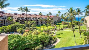 A hotel with multiple buildings, a well-maintained lawn, and palm trees. - Kamaole Sands 3-406 - Modern Kitchen, Large Lanai, Enclosed Private MB, Split AC (Kihei)