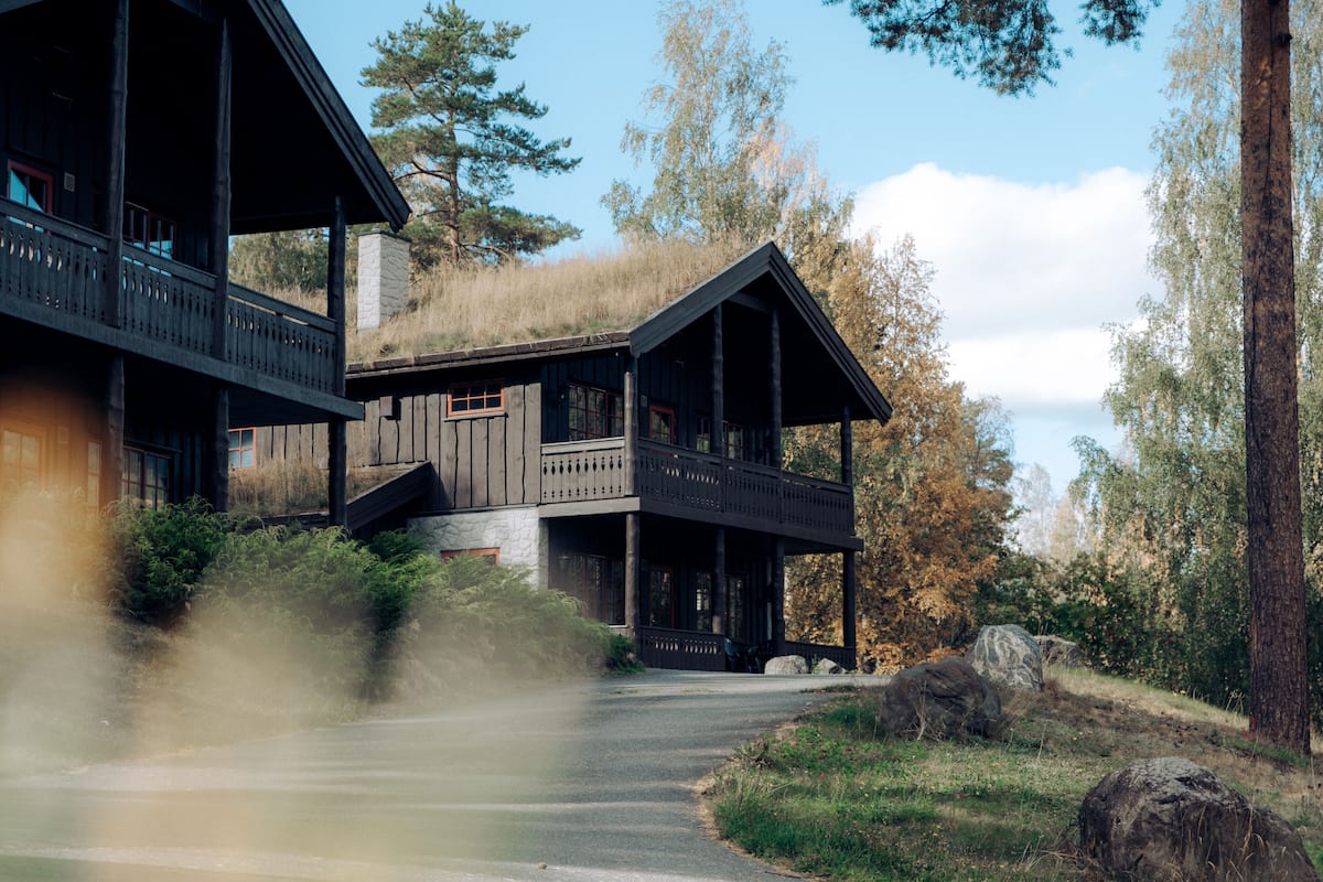 Une cabane rustique avec une façade en bois, un balcon et une cheminée en pierre.