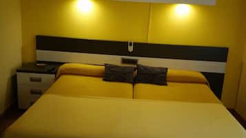 Ein Bett mit Kopfteil, Nachttischen und einer Wandlampe.