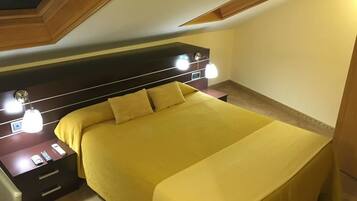 Ein Schlafzimmer mit einem Bett, Nachttischen und einem Kopfteil mit Beleuchtung.
