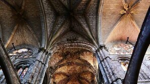 An interior of a cathedral with high vaulted ceilings and stained glass windows. - Hostal Doña Juana (Ávila)