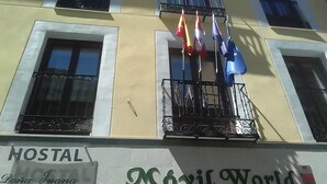 A building with a sign reading "HOSTAL" and "Móvil World" on the facade. - Hostal Doña Juana (Ávila)