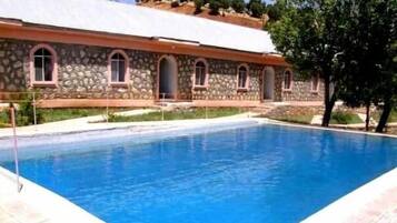 Een buitenzwembad, parasols voor strand/zwembad