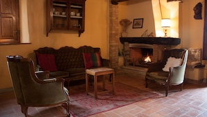 A cozy living room with a fireplace, a wooden cabinet, and a comfortable sofa.