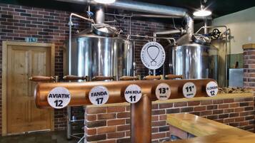 Een bargedeelte met roestvrijstalen biertaps voorzien van biernaam en temperatuur.