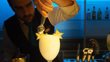 A bartender preparing a cocktail with a spoon.