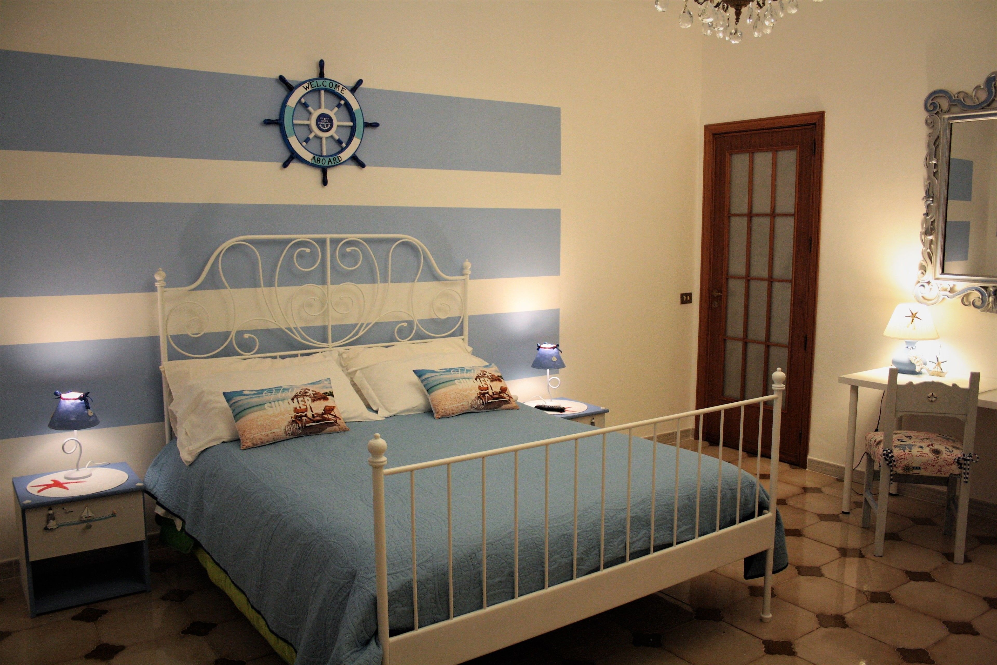 Une chambre à coucher comprenant un lit, des tables de chevet, un bureau, une chaise, un miroir et une horloge murale.