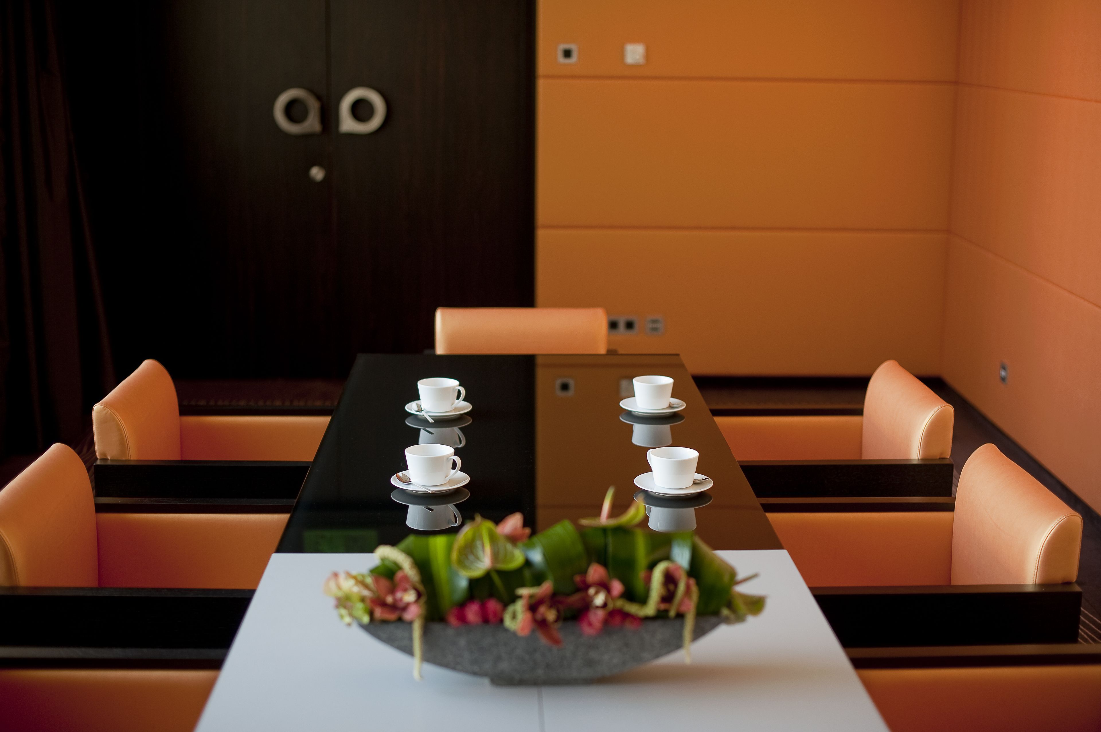 A conference room with a long table, multiple chairs, and a decorative centerpiece.
