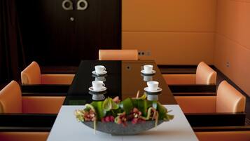 A conference room with a long table, multiple chairs, and a decorative centerpiece.