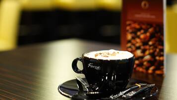 A cup of coffee on a saucer with a menu stand in the background.