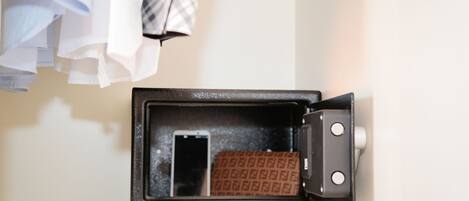 Uma mala com interior estampado, um smartphone e uma trava de metal.