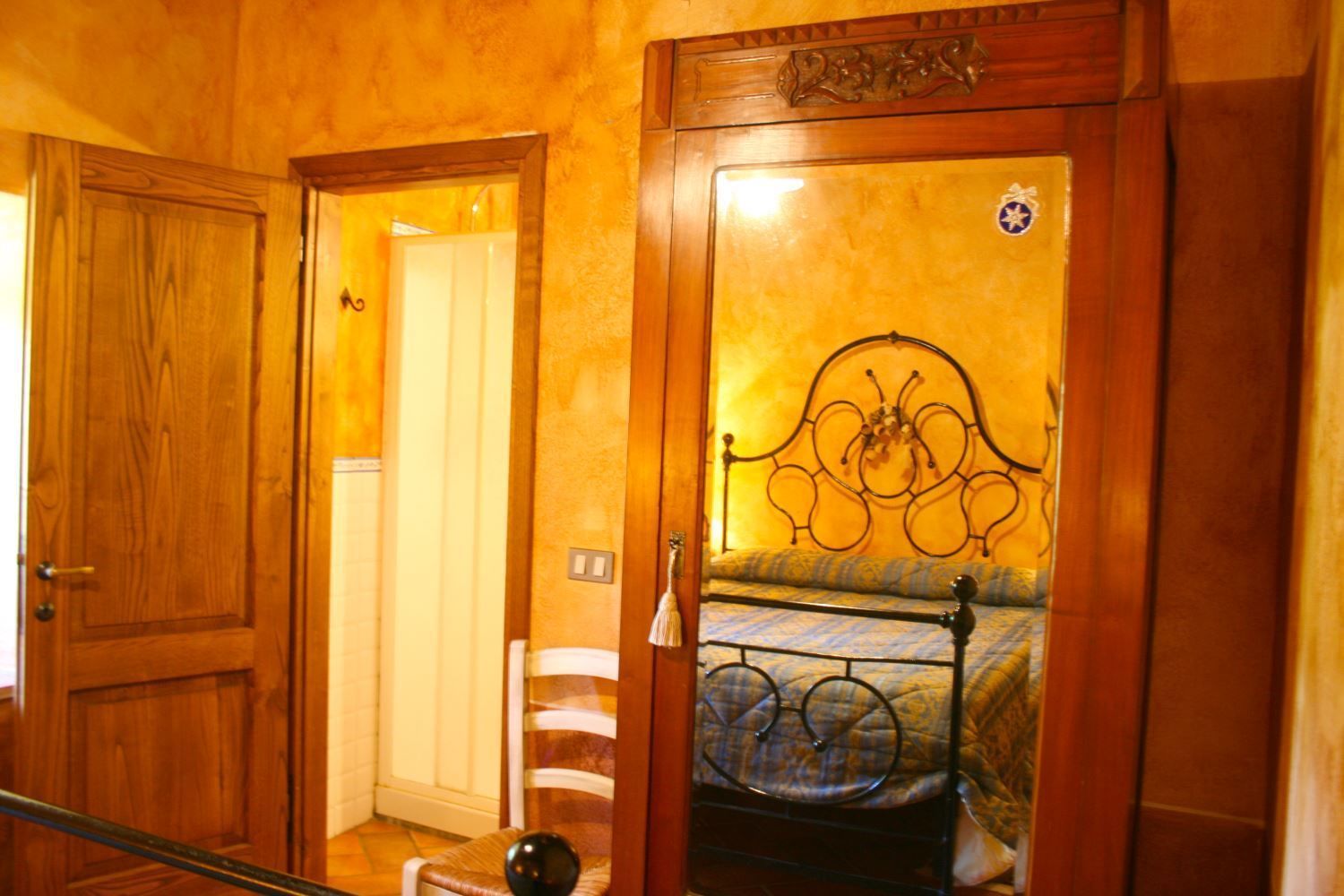 Un dormitorio con puerta de madera, una cama con estructura de metal y una silla pequeña.