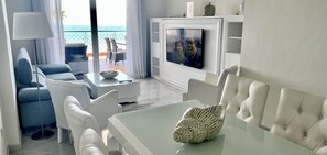 Departamento, 2 habitaciones, Terraza, vista al mar | Sala de estar | Smart TV de 55 pulgadas con canales vía satélite, televisión y Netflix