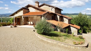 A stone house with a tiled roof, a covered patio, and a gravel driveway. - Wonderful private villa for 10 people with private pool, WIFI, TV, terrace, pets allowed and par... (Castel San Niccolo)