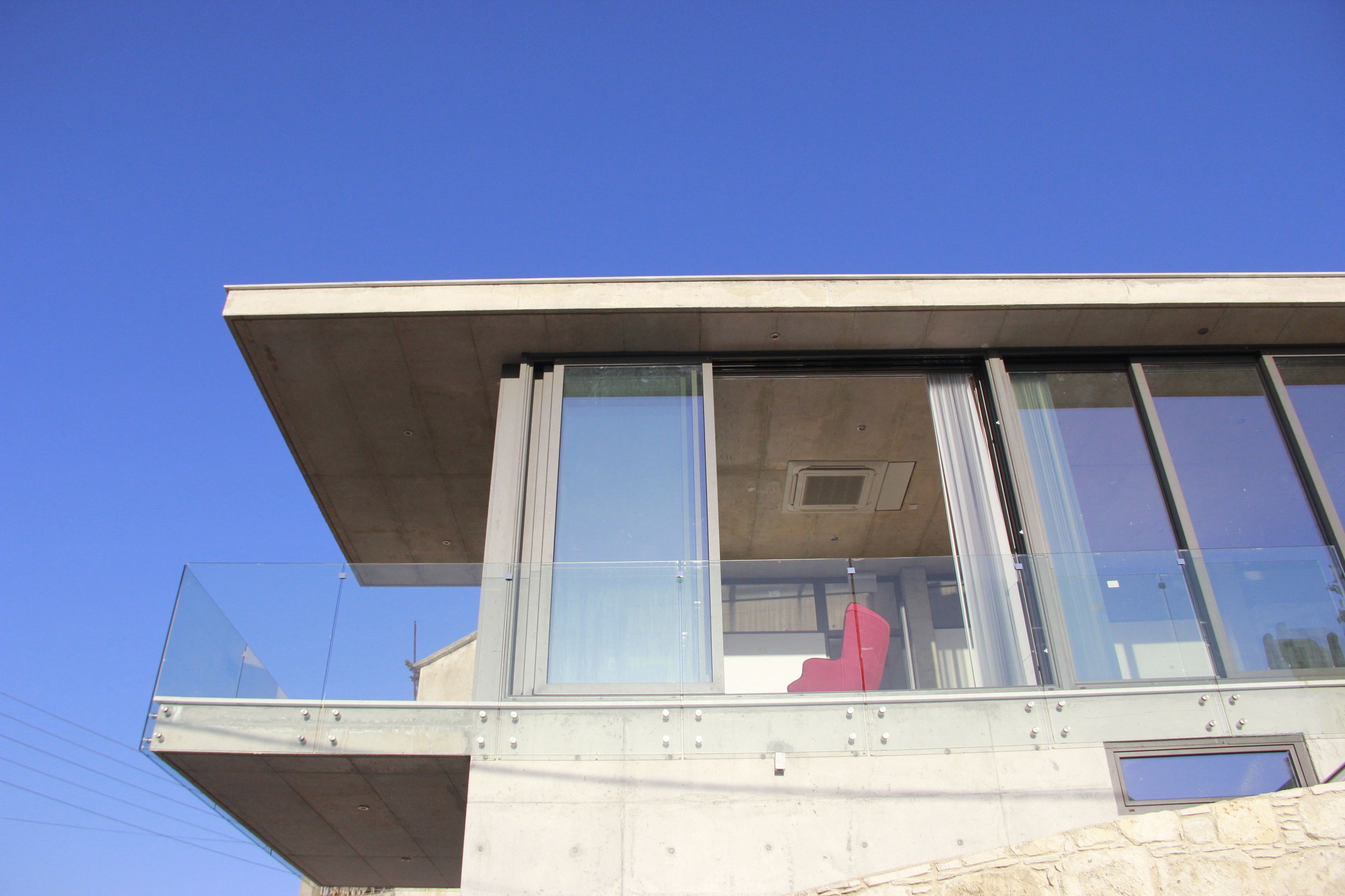 A modern building with large windows and a concrete exterior.