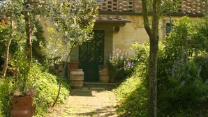 A traditional building with a garden pathway leading to a green door. - Private Villa with AC, private pool, WIFI, TV, terrace, pets allowed, parking, close to Arezzo (Castiglion Fiorentino)