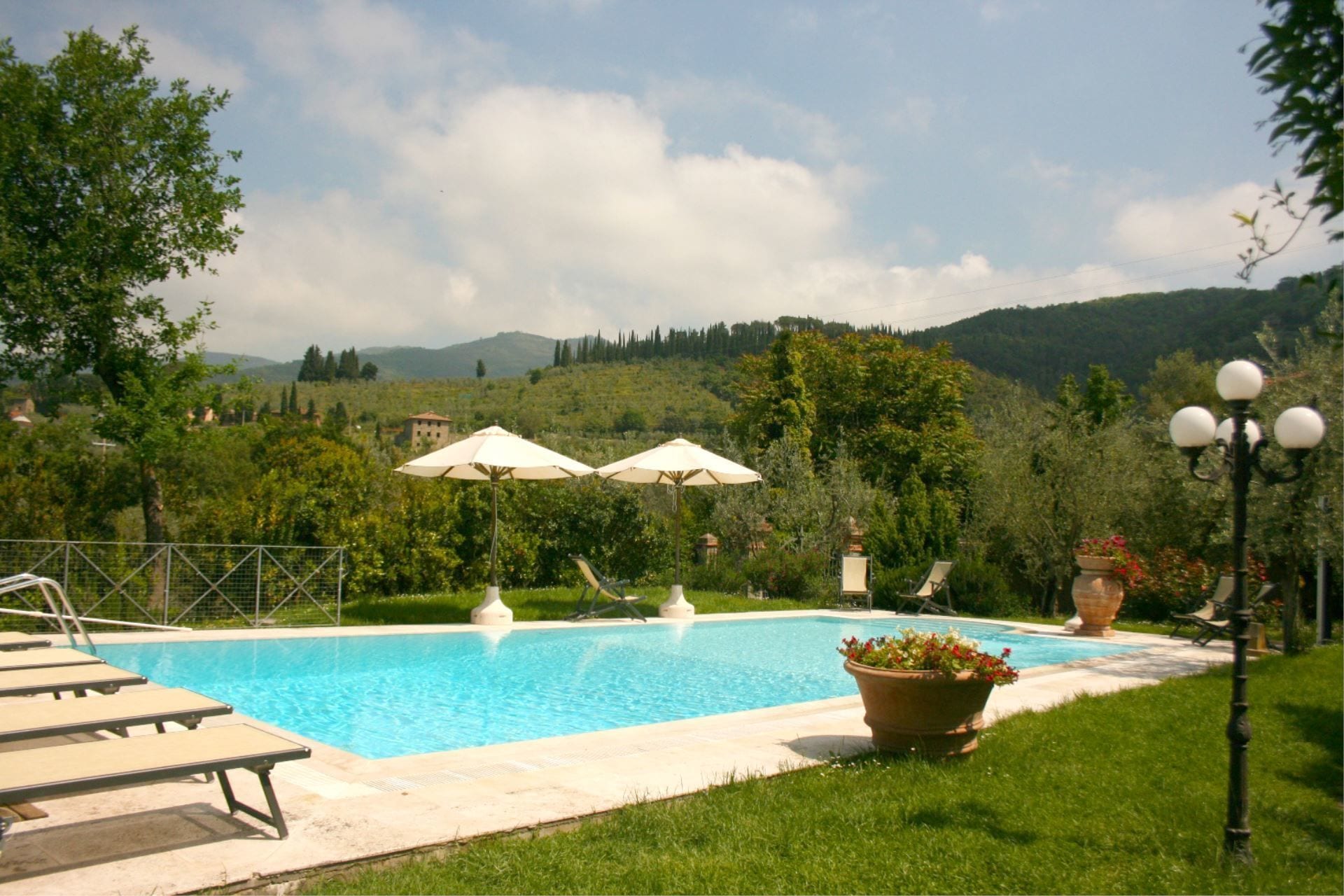 En säsongsöppen utomhuspool, parasoller och solstolar