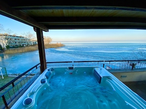 A hot tub with a view of a frozen lake and buildings in the background. - Royal Mediterran Hotel (Siófok)