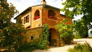A rustic brick house with two arches and a small porch area. - Stunning private villa for 6 guests with private pool, TV, pets allowed and parking (Castiglion Fiorentino)