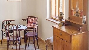 A room with a wooden desk, a chair, a table, and a window with a view. - Casa Arthur (Biertan)