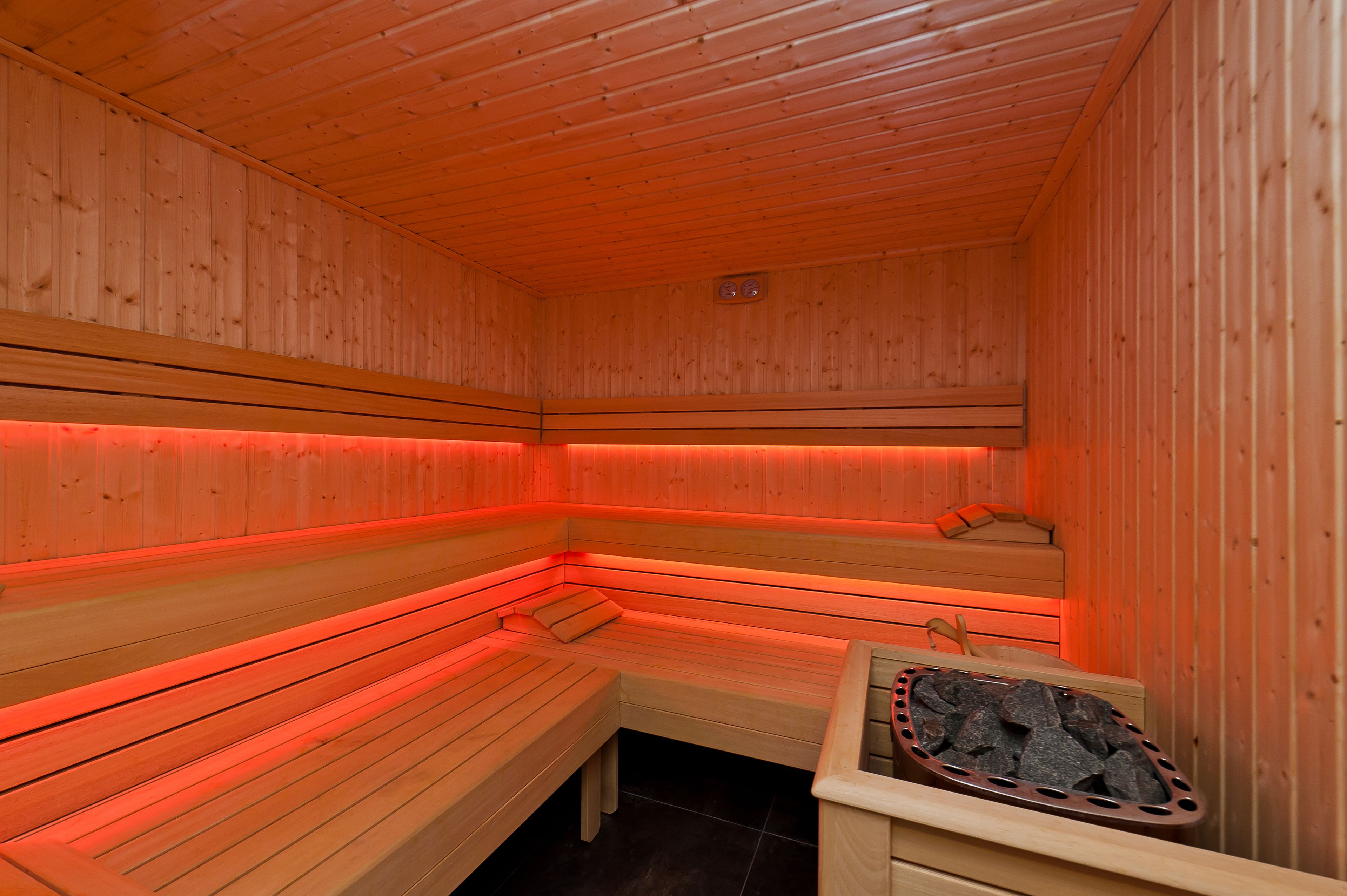 A wooden sauna with benches and a stone basin.