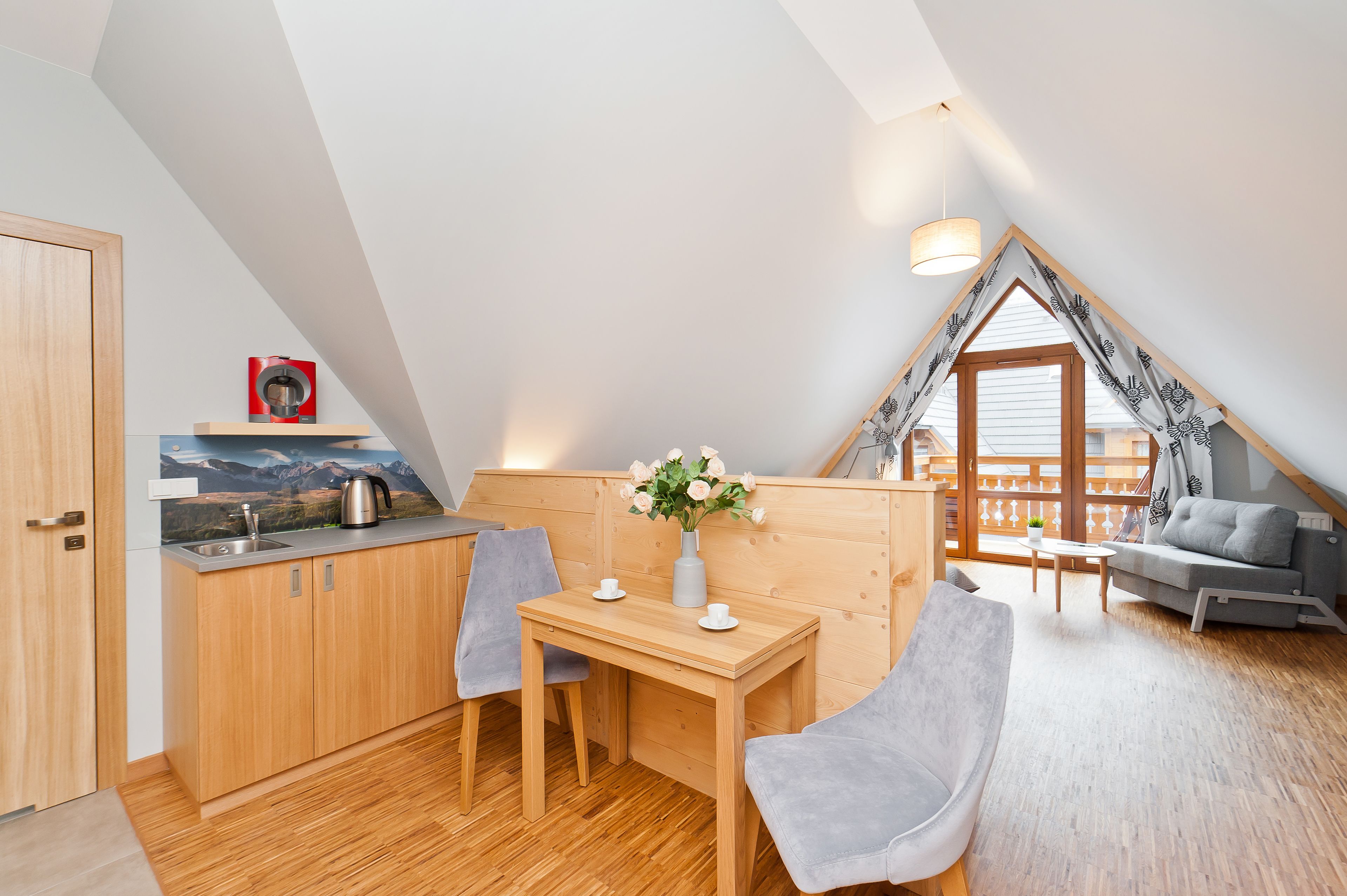 A cozy, modern loft with a kitchen, dining area, and seating space.