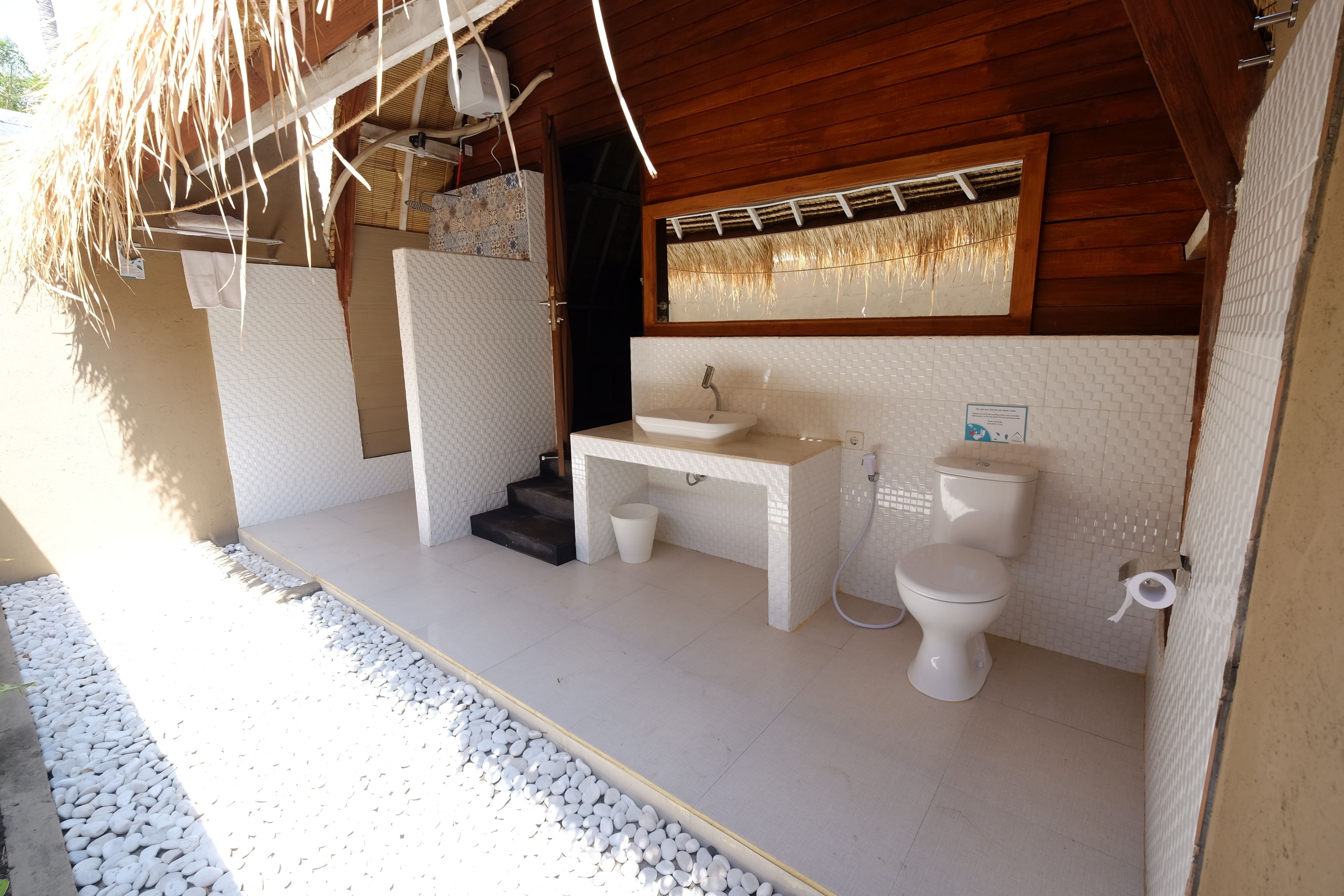 Een badkamer met een wit wastafelmeubel, toilet en douche.