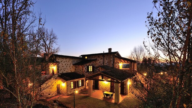 A stone house with a patio and a small pond, surrounded by trees. - Borgo Saint George (Otricoli)